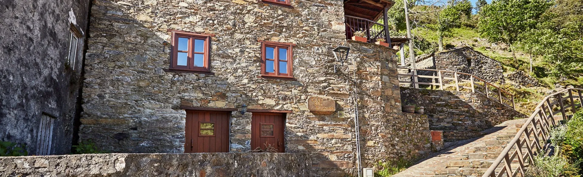 Fachada em xisto da Casa das Bugalhas ao sol, no Candal
